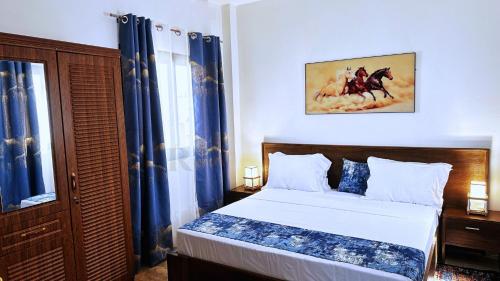 a bedroom with a bed with blue curtains at Res'Zac in Rufisque