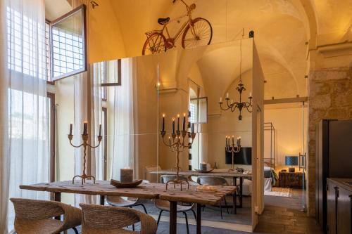 a dining room with a table with a bike on the ceiling at Dimora Enricuzzo Modica in Modica