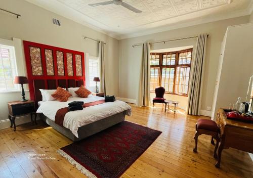 a bedroom with a large bed with a red headboard at The Franklyn Parkview in Johannesburg