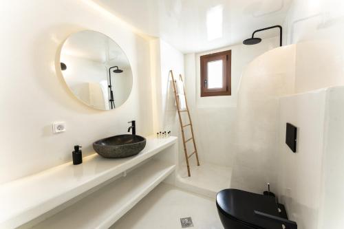 a bathroom with a sink and a mirror at Leon Luxury Suites in Imerovigli