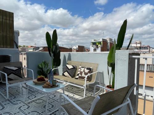 a patio with chairs and a table on a balcony at Ático a 15 min en tren del centro in Sant Adria de Besos