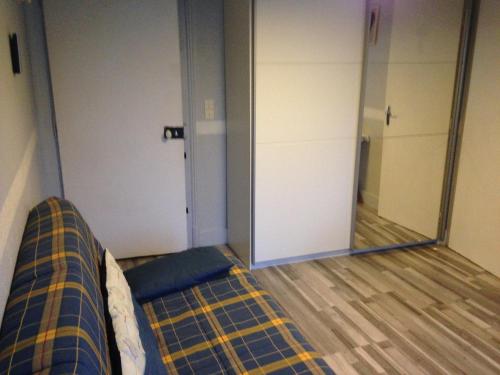 a room with a couch and a large mirror at Studio Plaisance in Contrexéville