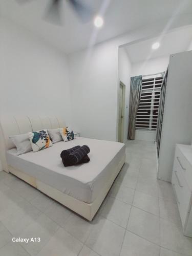 a white bedroom with a large bed in a room at Nova Stay SP in Sungai Petani