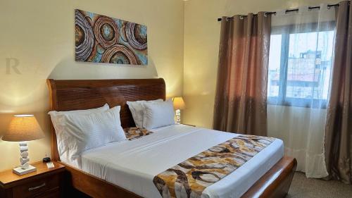 a bedroom with a large bed and a window at Res'Zac in Rufisque
