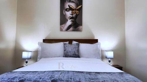 a bedroom with a white bed with two lamps at Res'Zac in Rufisque