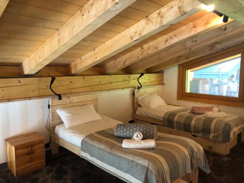 une chambre avec deux lits dans une cabane en rondins dans l'établissement Mountain Cabin - vue montagne - 4 personnes, aux Houches