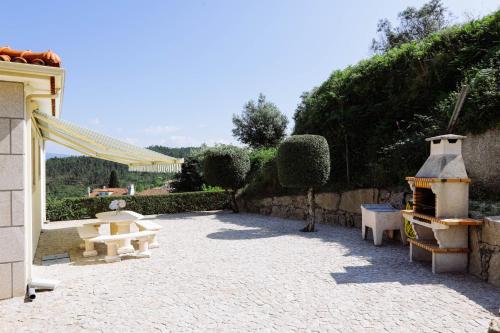 un patio con mesa de picnic y parrilla en Casa Fundevila Celorico de Basto by AloTur, en Celorico de Basto