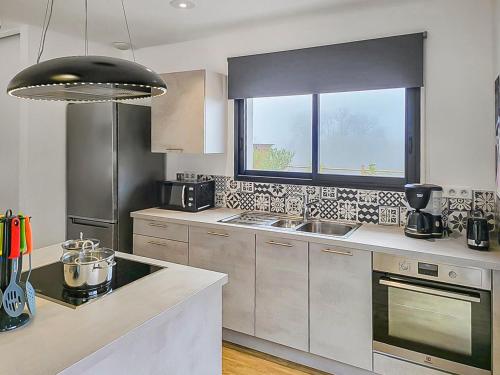 a kitchen with stainless steel appliances and a window at Gîte 2 Newlook in Trélissac