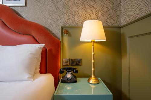a lamp sitting on a table next to a bed at Elmbank York, Tapestry Collection by Hilton in York