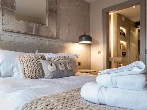 a bedroom with a white bed with a large mirror at Arran Shores 2 in Lamlash