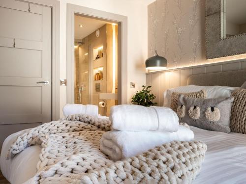 a bedroom with a bed with a pile of white towels at Arran Shores 3 in Lamlash