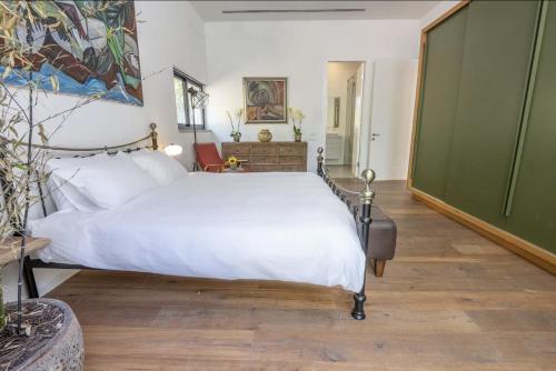 a bedroom with a white bed and a chair at New Luxurious Villa in Kerem Maharal in Kerem Maharal