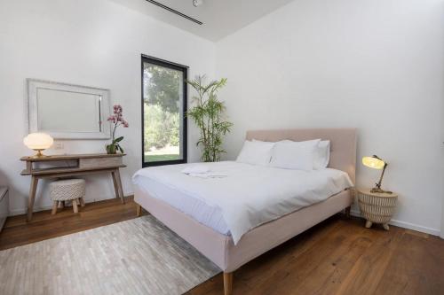 a bedroom with a bed and a desk and a window at New Luxurious Villa in Kerem Maharal in Kerem Maharal