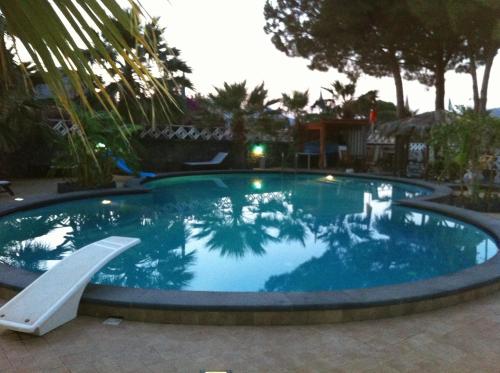 a large swimming pool with a slide in a yard at Hotel Al Togo Fitness & Relax in Vulcano