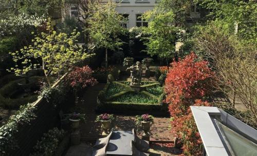 阿姆斯特丹荷兰大师短期出租公寓式酒店的一座花园,花园内拥有喷泉和许多植物