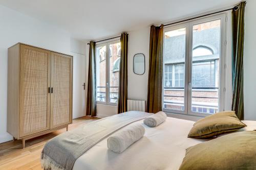 une chambre avec un grand lit et deux fenêtres dans l'établissement Montmartre l Close to Sacré-Coeur & Rue des Abbesses, à Paris