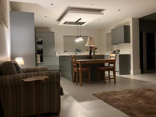 a kitchen and living room with a couch and a table at Gelilah House in Loughbrickland