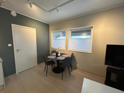 a dining room with a table and chairs and a television at Eide Aurora Apartement in Tromsø