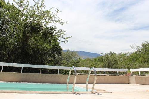 a swimming pool with a metal handrail in front of a fence at Jauja in San Javier