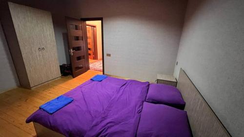 a purple bed in a room with a hallway at Gabala Dreams in Gabala