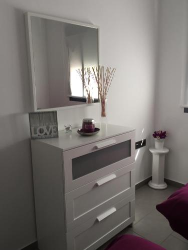 a bathroom with a white dresser with a mirror at Apartment OasisBeach La Zenia in Playas de Orihuela