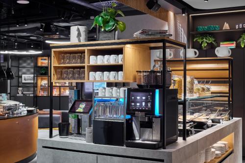 a coffee shop with a coffee machine on a counter at H2 Hotel Saarbrücken in Saarbrücken