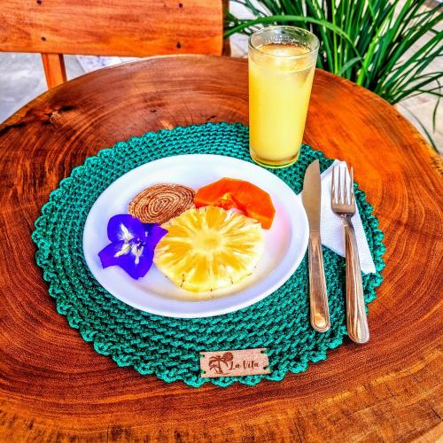 a plate of food on a table with a glass of orange juice at Pousada La Vita in São Miguel dos Milagres