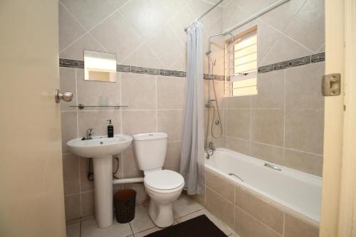 a bathroom with a toilet and a sink and a tub at Michael Point 6 in Shelly Beach