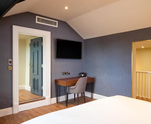 a bedroom with a desk and a tv on a wall at Elmbank York, Tapestry Collection by Hilton in York