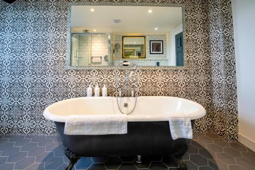 a bath tub in a bathroom with a mirror at Elmbank York, Tapestry Collection by Hilton in York