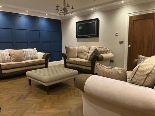 a living room with couches and a flat screen tv at Gelilah House in Loughbrickland