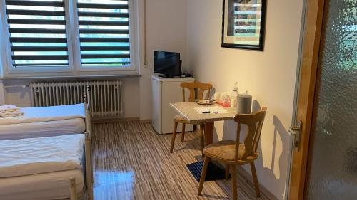 a small room with a small table and a bed at Gästehaus Rachinger in Pappenheim