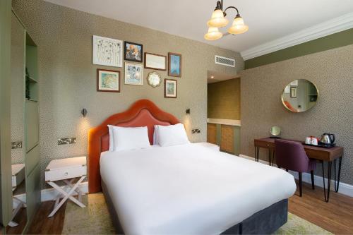 a hotel room with a large bed and a desk at Elmbank York, Tapestry Collection by Hilton in York