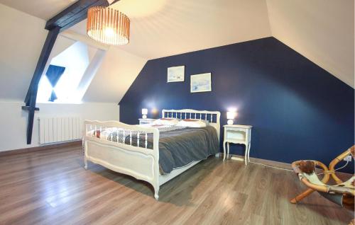 une chambre avec un lit et un mur bleu dans l'établissement Nice Home In Saint Marcouf With Wifi, à Saint-Marcouf