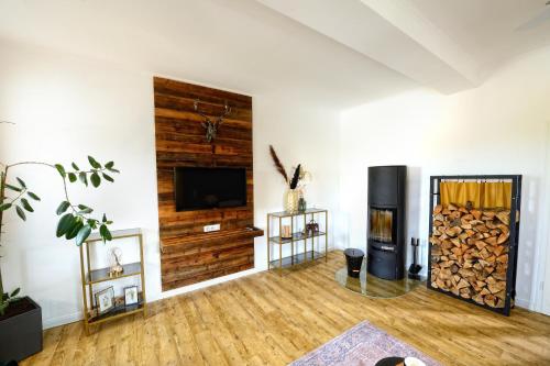 Il comprend un salon doté d'une cheminée et d'une télévision à écran plat. dans l'établissement Chalet-Apartement in ehemaliger Hofraite, à Bruchköbel