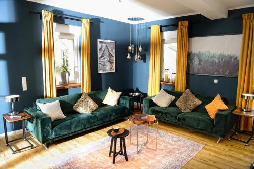 - un salon avec un canapé vert et des rideaux jaunes dans l'établissement Chalet-Apartement in ehemaliger Hofraite, à Bruchköbel