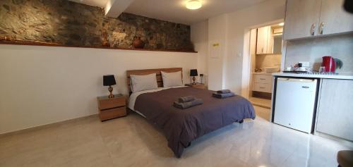 a bedroom with a bed and a small kitchen at Chic Elegance Meets Village Gem in Pelendri