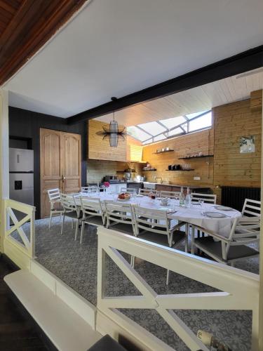 une salle à manger avec des tables blanches et des chaises blanches dans l'établissement Le Pavillon de l'Intemporelle Bagnères de Bigorre, à Bagnères-de-Bigorre