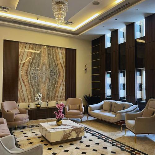 a lobby with chairs and a table and a painting at Amman Paradise Hotel in Amman