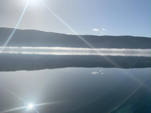 a view of the water with the sun in the background at Seefels Appartements in Döbriach