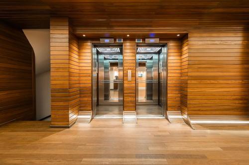 a hallway with three elevators in a building at Hotel Beyond in Izmir