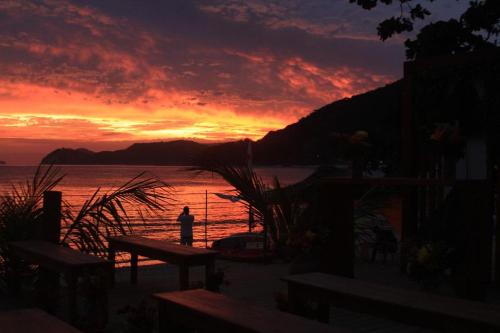 a person standing on the beach at sunset at Por do sol Boiçucanga in São Sebastião