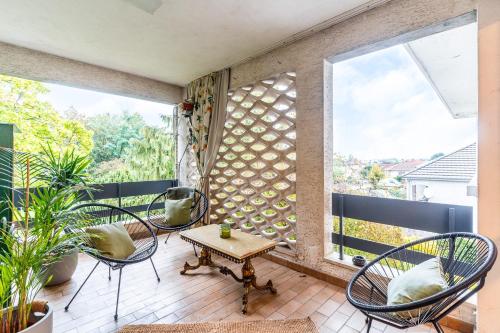 d'un balcon avec des chaises, une table et une fenêtre. dans l'établissement Mélodie Mosellane - Charmant appt avec jardin, à Metz