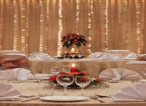 a table with wine glasses and a candle on it at Hometel Chandigarh in Chandīgarh
