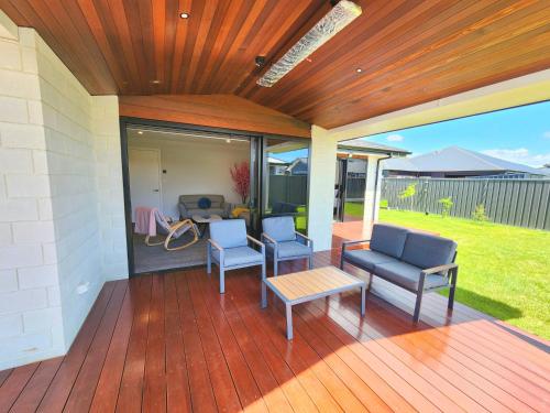 eine Terrasse mit zwei Stühlen und einem Tisch auf einem Deck in der Unterkunft The Cozy Oasis in Napier