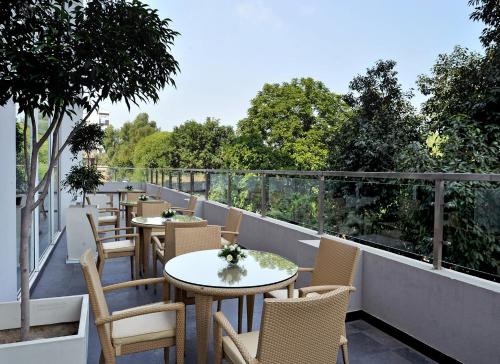 a patio with tables and chairs on a balcony at Hometel Chandigarh in Chandīgarh
