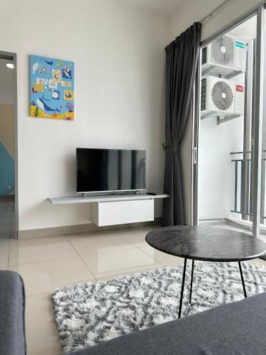 a living room with a tv and a table at Bayu Temiang - 5pax Quiet Home in Seremban