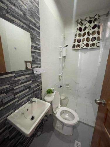 a bathroom with a white toilet and a sink at EMILIEZ PLACE in Baguio