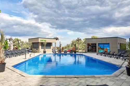 a large blue swimming pool with chairs and a building at Apartament Atlantis by ALZ in Mamaia Nord