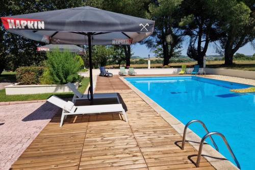 un parasol et des chaises à côté d'une piscine dans l'établissement Domaine de la Tour de Pérès, à Ayguetinte